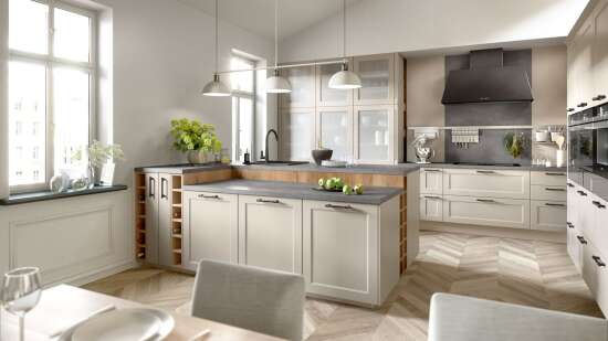 Moderne, helle Küche mit weißen Schränken, grauen Arbeitsflächen, Kücheninsel, Hängelampen und großen Fenstern.
