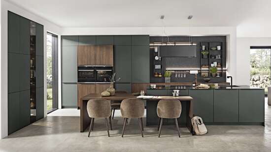 Stilvolle Küche mit grünen und hölzernen Schränken, integriertem Ofen, Kochinsel, Essbereich mit vier Stühlen und dekorativen Elementen.